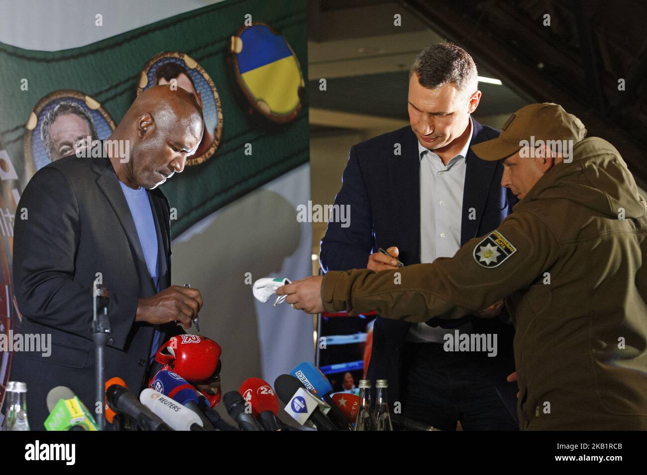 Ex Boxing Champions of the World Evander Holyfield (L) and Kiev's Mayor and former heavyweight boxing champion Vitali Klitschko (C) gives signatures during an authographs signing event on the 56th WBC ( World Boxing Council ) Convention in Kiev, Ukraine, 02 October, 2018. The 56th WBC Convention takes place in Kiev from September 30 to October 05. The event participate of boxing legends Lennox Lewis, Evander Holyfield, Eric Morales, Alexander Usik, Vitali Klitschko and about 700 congress participants from 160 countries. (Photo by NurPhoto) Stock Photo