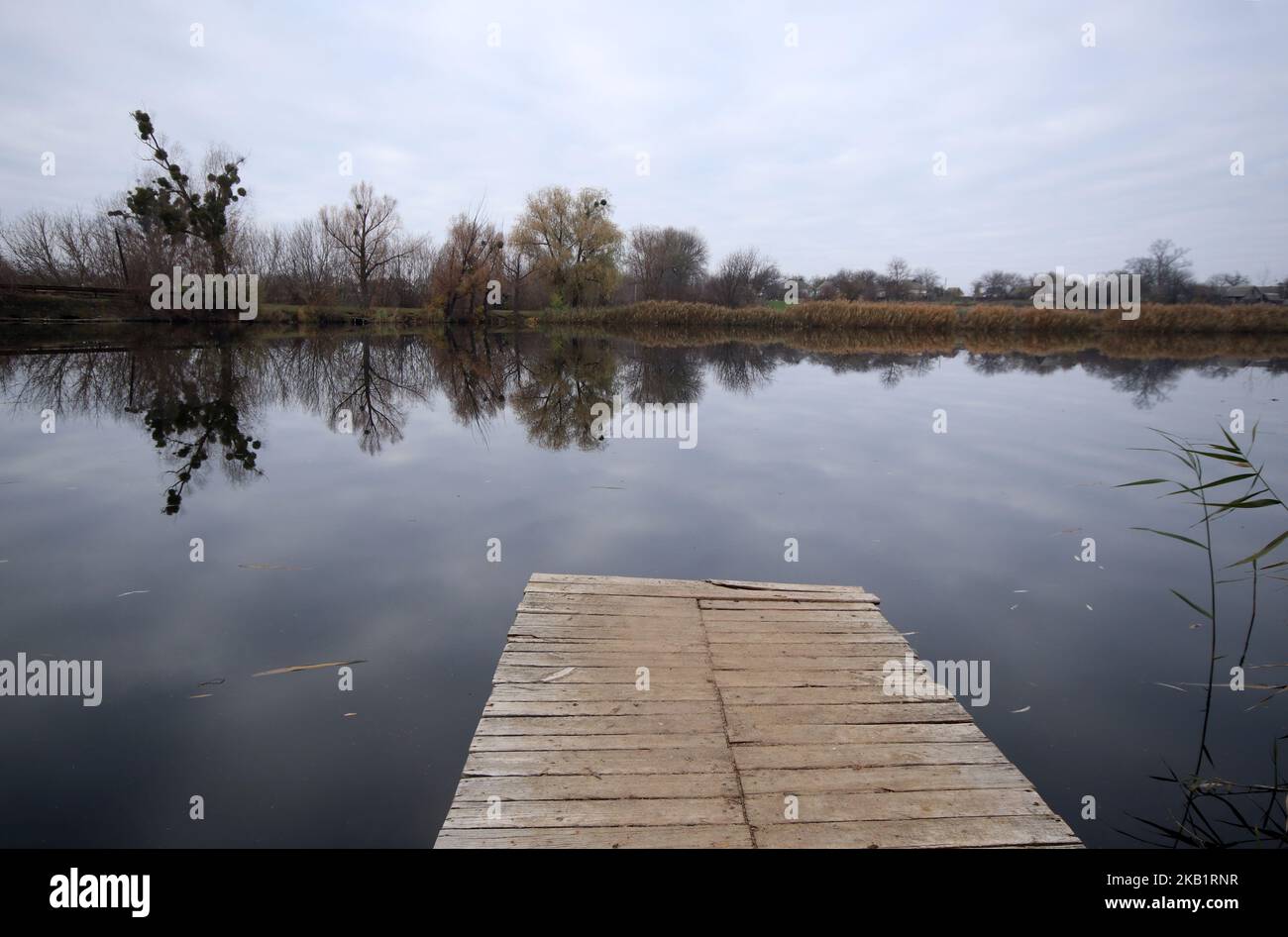 Fishing spot. Empty wooden deck floor over the lake. Stock Photo