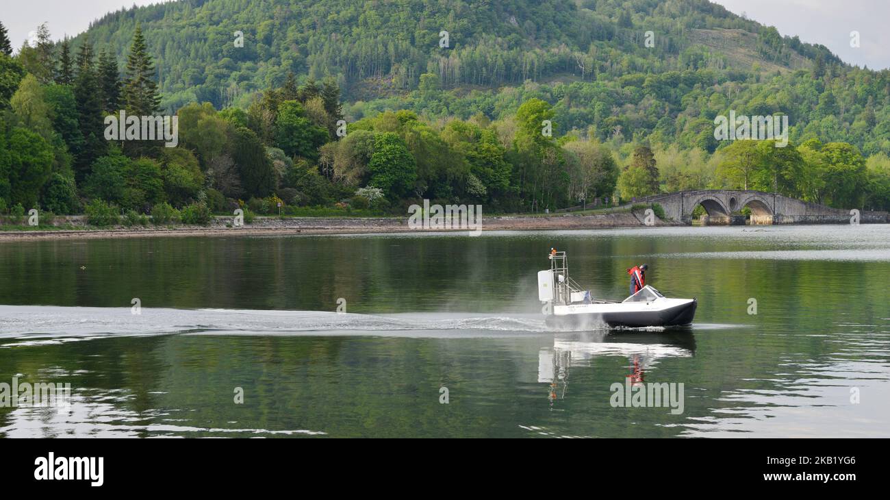 Small hovercraft on Loch Fyne at Inverary Scotland with Inverary Castle and Bridge in the background Stock Photo