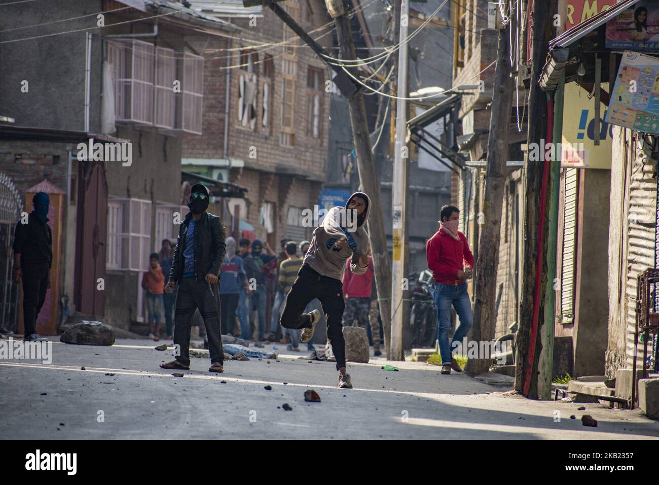 Kashmiri protesters throw stones at Indian government forces, during a protest against the killing of a Kashmiri rebel commander on October 12, 2018 in Srinagar, the summer capital of Indian administered Kashmir, India. Kashmiri youth clashed with Indian government forces who were deployed in strength in different parts of Srinagar on Friday to prevent protests against the killing of a Kashmiri rebel commander in Kupwara district of Indian-administered Kashmir the previous day. Manan Wani, who had quit his doctorate in Geology at an Indian university to join the Hizb-ul-Mujahideen militant out Stock Photo