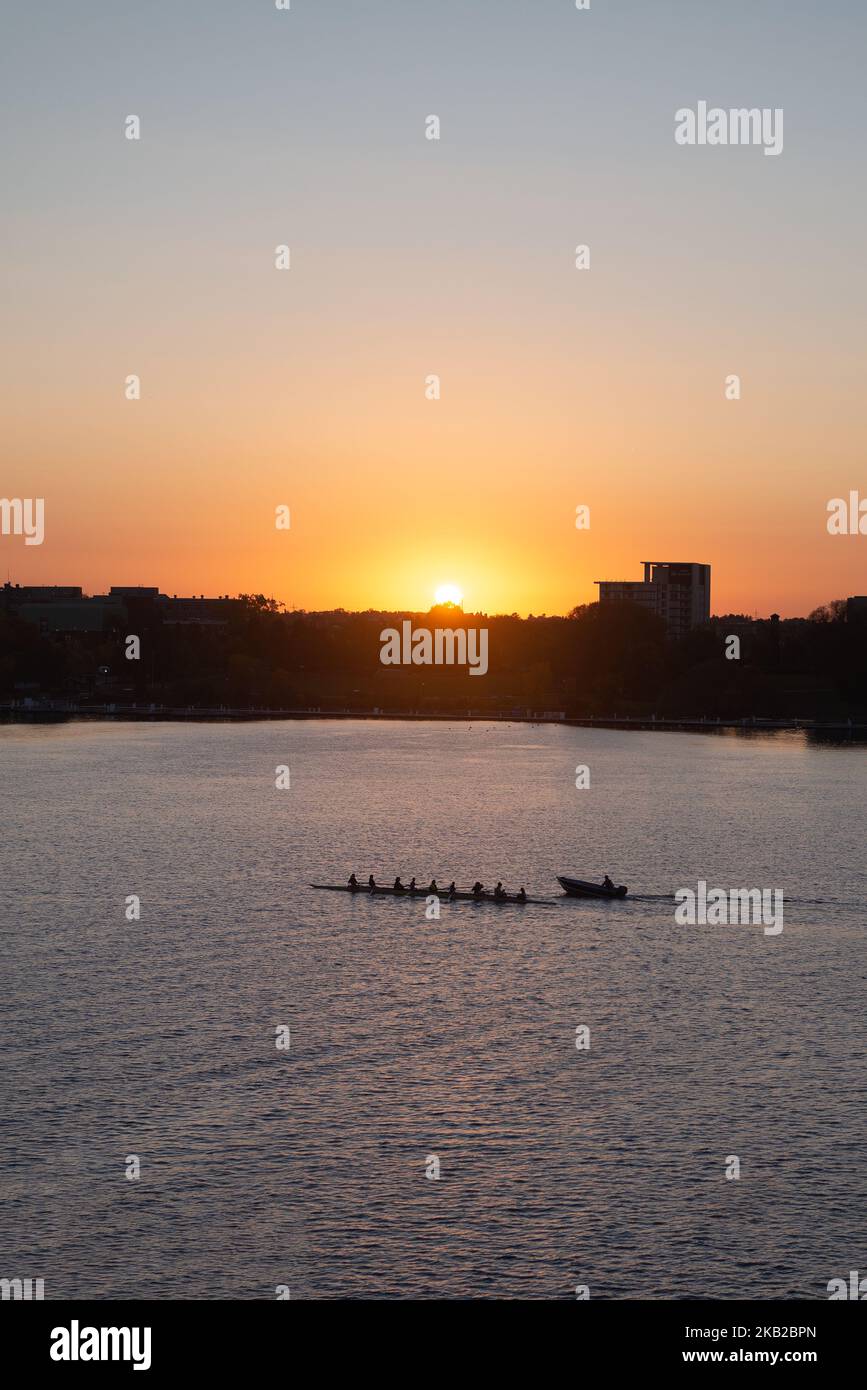 Colorful Sunset Ottawa River rowing team training silhouette Stock