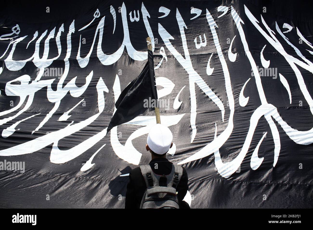 Indonesian Muslims carrying Tawheed flags and other attributes staged