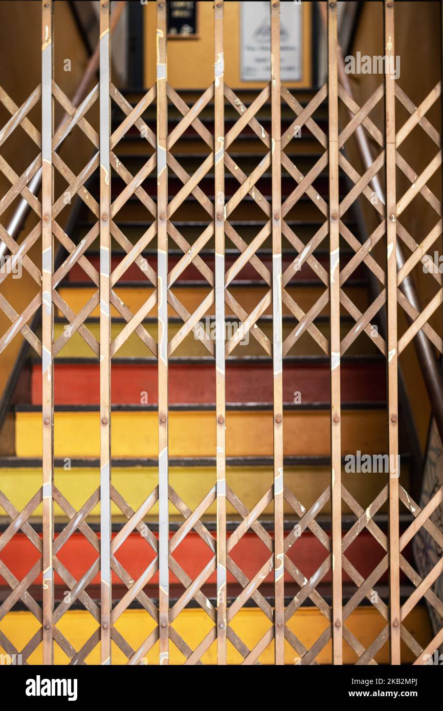 Painted stairs and a metal accordion security gate make a geometric