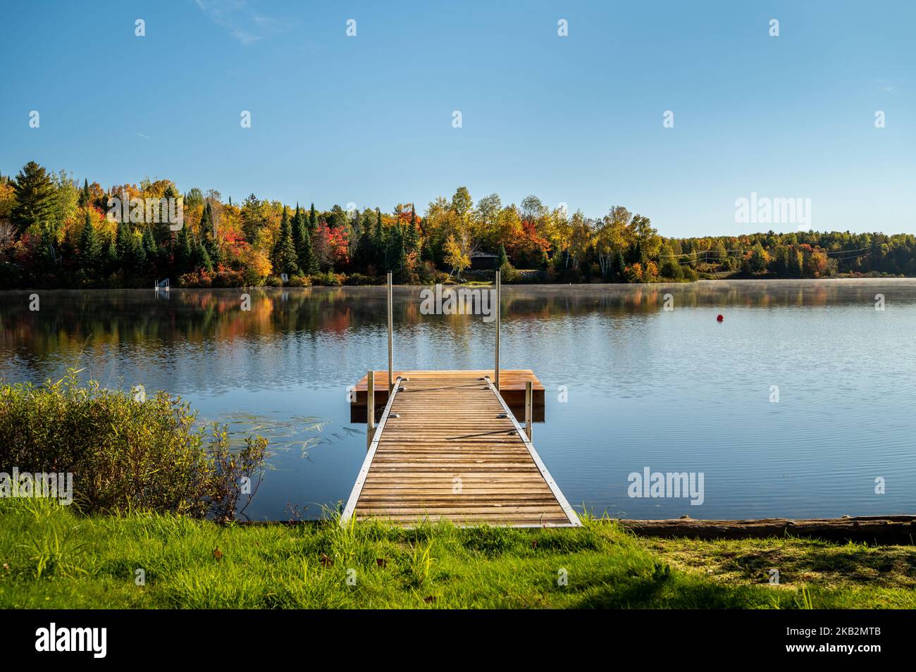 Fall colors trees reflecting on lake Stock Photo - Alamy