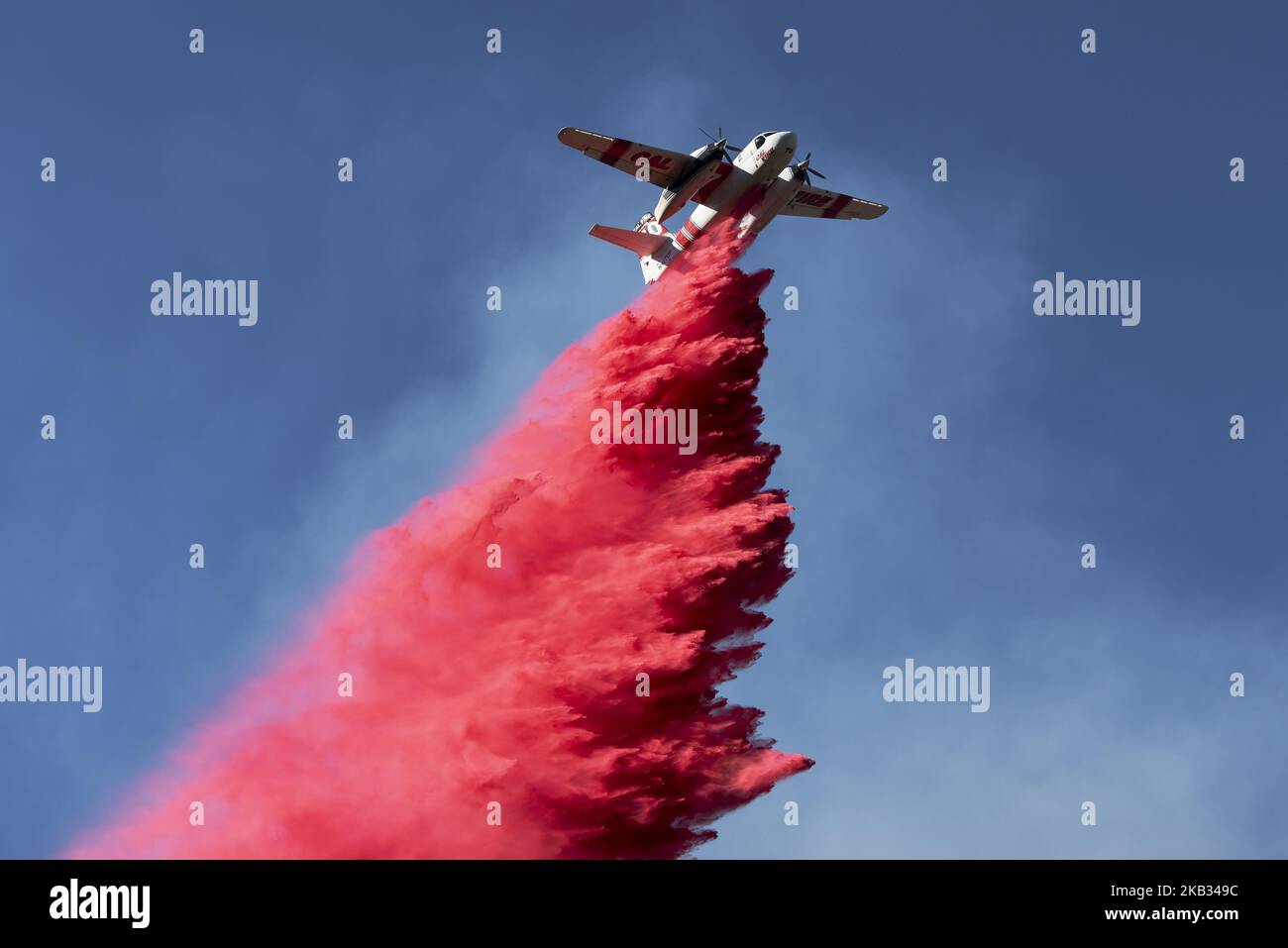 A plane drops fire retardant on the Woolsey Fire near Malibu, California on November 12, 2018 . The Woolsey fire has burned more than 143 square miles and evacuation orders were issued to 265,000 people in Los Angeles and Ventura counties (Photo by Ronen Tivony/NurPhoto) Stock Photo