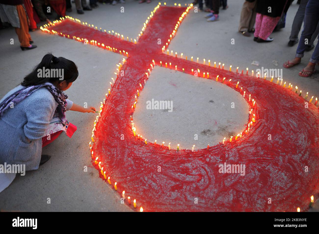 A girl lit candles around the symbol of RED AIDS during Eve of the