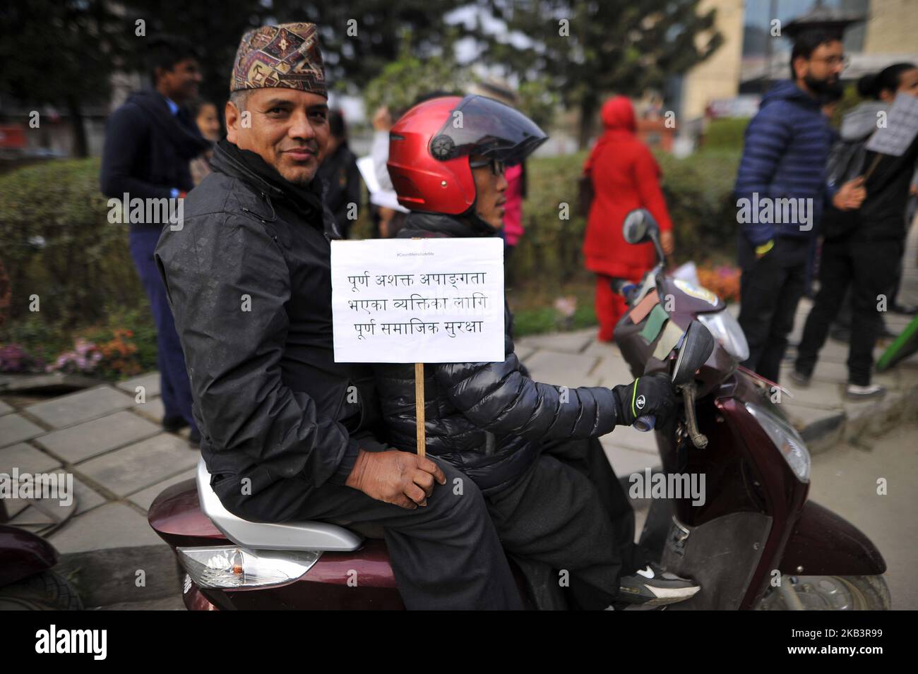 A Nepalese disabled people in a scooter hold placards during 27th International Day of Persons with Disabilities in Kathmandu, Nepal on Monday, December 03, 2018. The 27th World Disability Day focuses on 'Empowering persons with disabilities and ensuring inclusiveness and equality'. (Photo by Narayan Maharjan/NurPhoto) Stock Photo