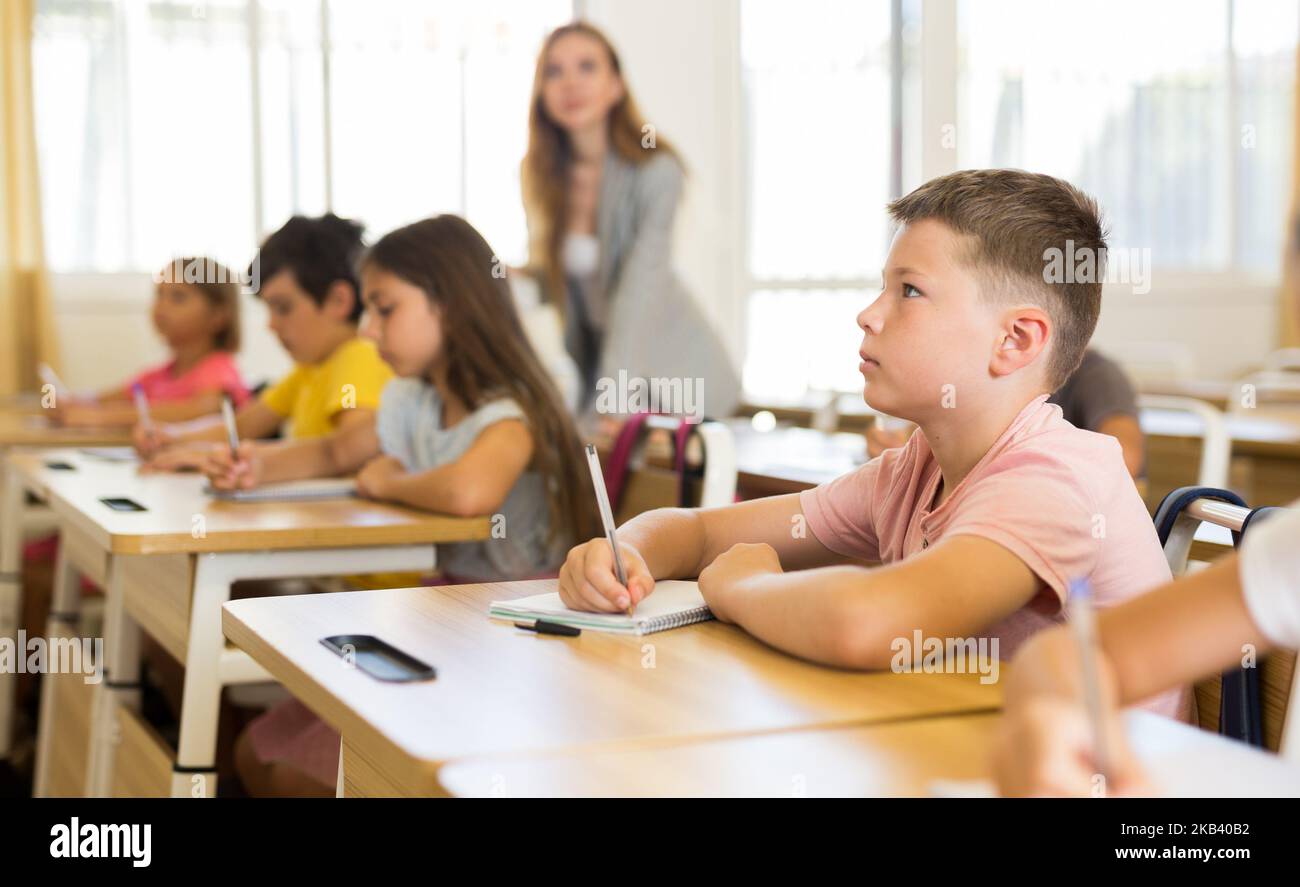 Schoolkids sitting at desks Stock Photo - Alamy