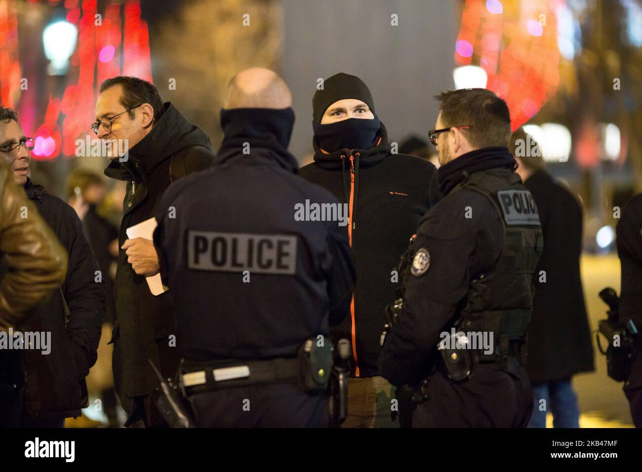 A French policeman speaks with colleagues on duty as he demonstrate on the Champs Elysées avenue on December 20, 2018 in Paris to the call of MPC (Mouvement of Angry Policemen) for the improvement of their working conditions. After more than one month monitoring Yellow Vest protests, French police officers who were already feeling overworked, say they have had enough. After several hours of negotiations between France's Interior Minister Christophe Castaner and France's three main police unions, an agreement was finally reached regarding officers' salaries. The French government has agreed to  Stock Photo