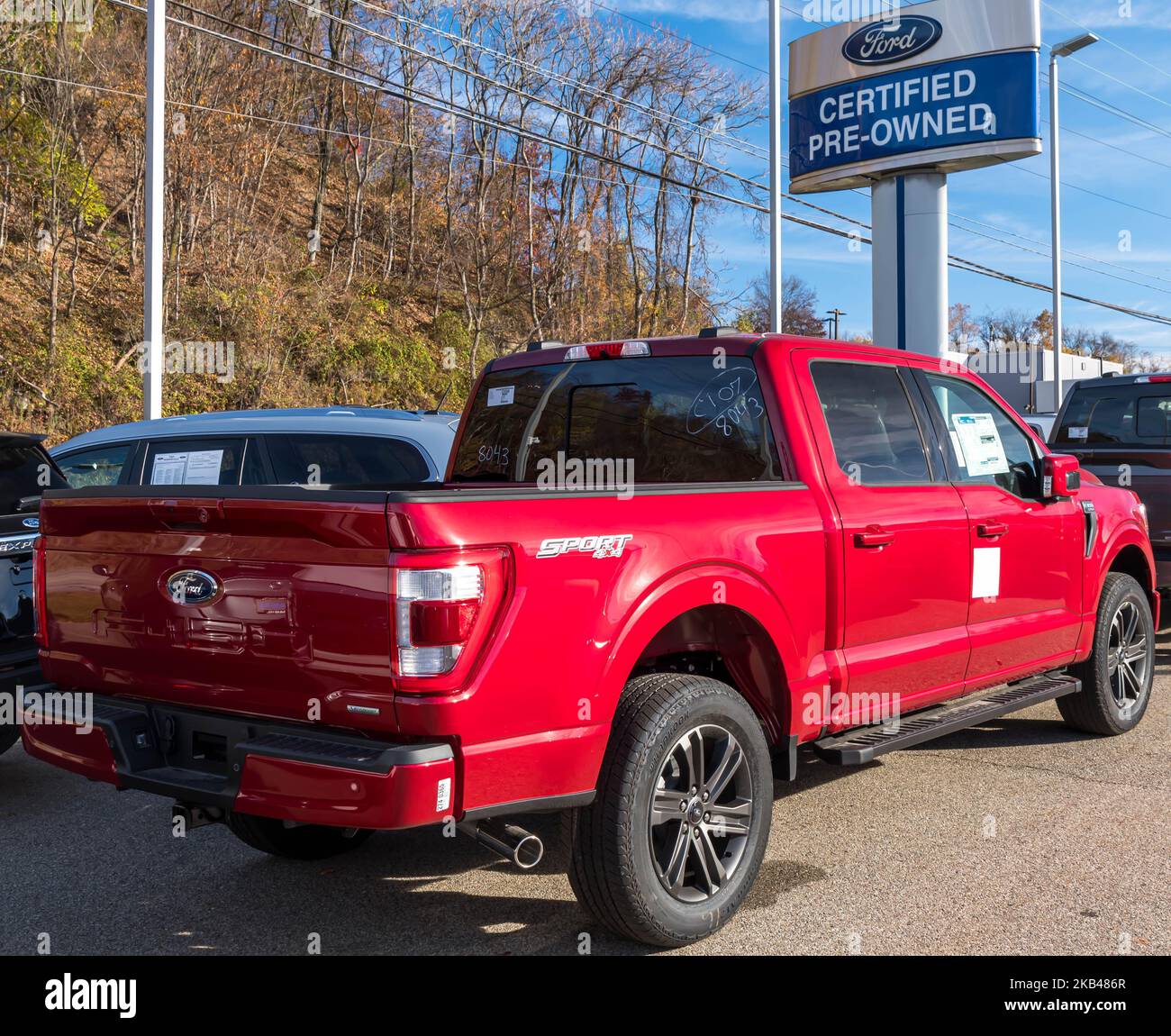 A red Ford F 150 pick up for sale at a dealership in Monroeville