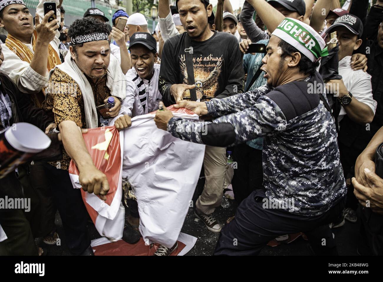 Jakarta, Indonesia, 21 December 2018 : Demonstrant Participants try to ripp off China flag during the demonstration. Arround thousand of muslims held demonstration in front of China Embassy-Jakarta to protest china action to minority Uyghur people at China who were sent what called as 'Education Camp' which believed as part of intimidiation to minority muslim at China. (Photo by Donal Husni/NurPhoto) Stock Photo