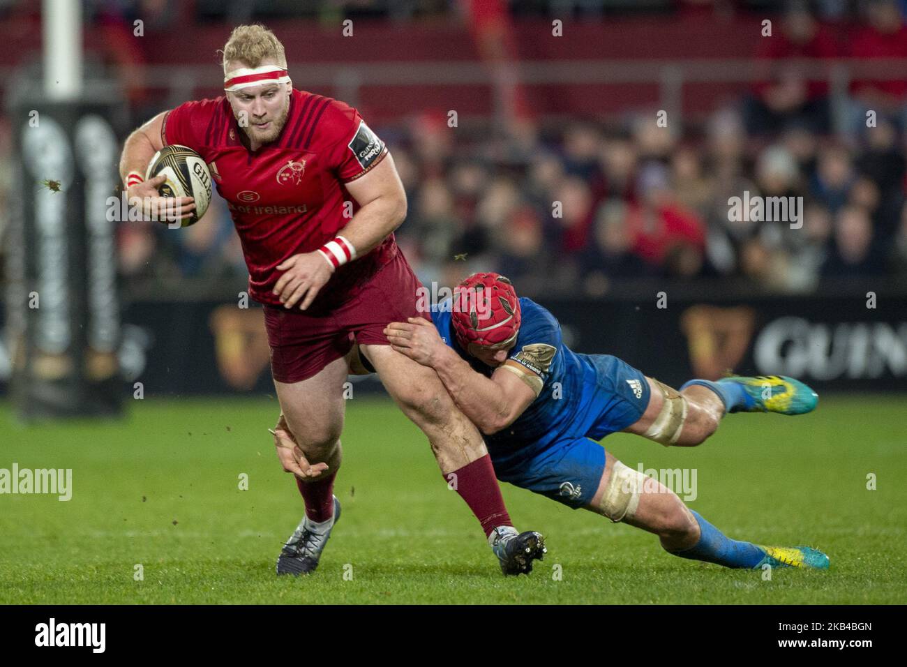 Jeremy Loughman of Munster with the ball tackled by Rhys Ruddock of ...