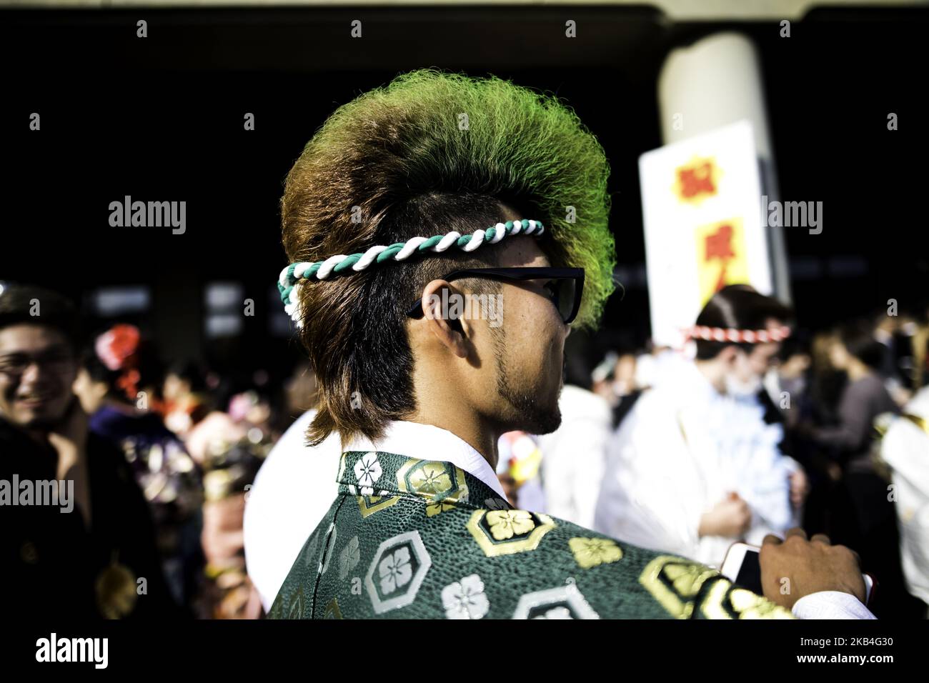 Okinawan man in a kimono holds an mobile phone as he photograph his ...