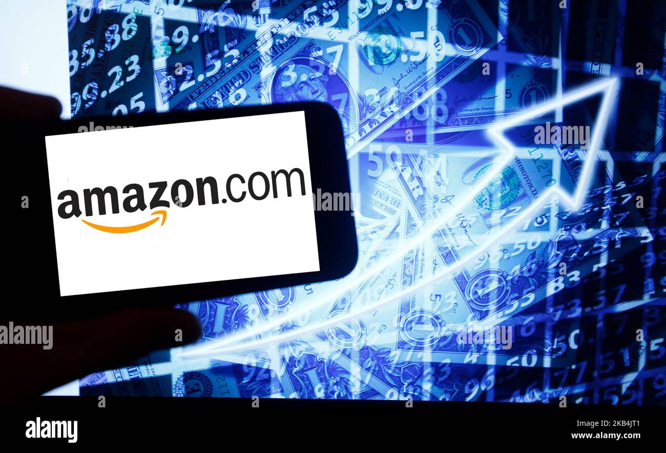 The logo of Amazon is seen on a screen of a smartphone next to a screen with an illustration ofthe stock market. Amazon is listed in Nasdaq. The Nasdaq is the second-largest stock exchange in the world after the New York Stock Exchange. (Photo by Alexander Pohl/NurPhoto) Stock Photo