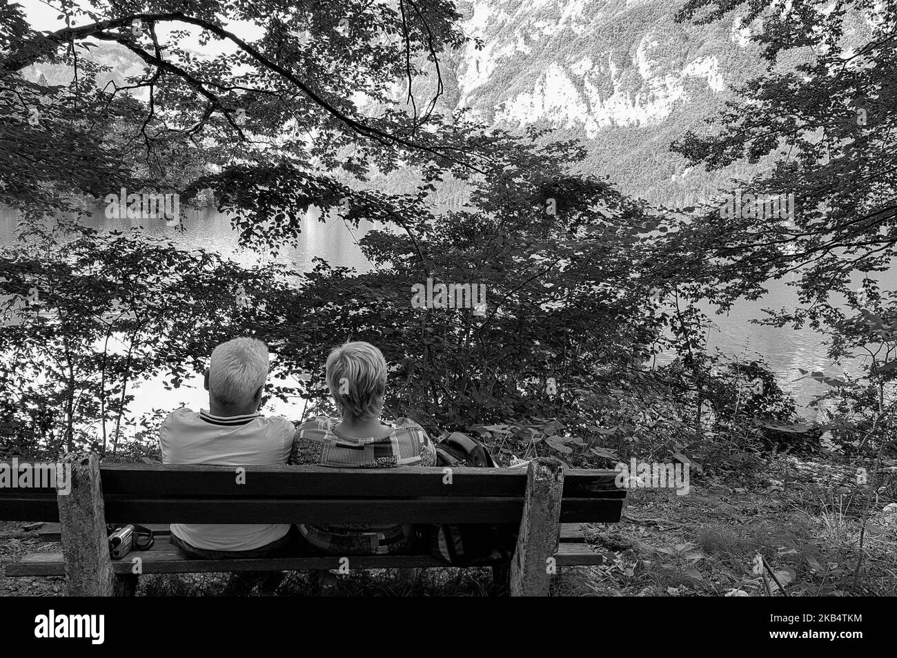 Couple sitting on a wooden park bench Black and White Stock Photos ...