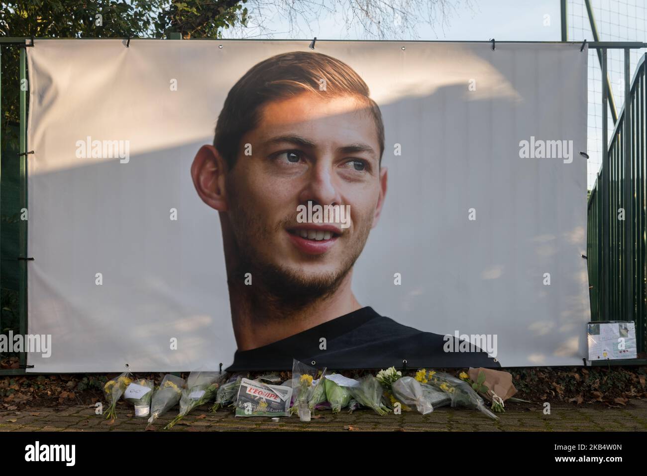 Flowers and candles are left with the front page of French sports daily