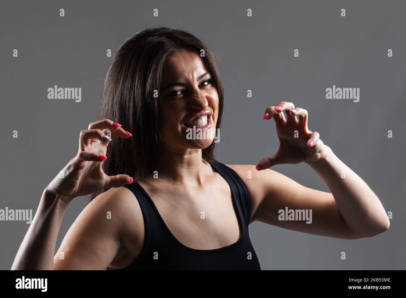 studio portrait of a beautiful angry brunette girl making hand gestures Stock Photo