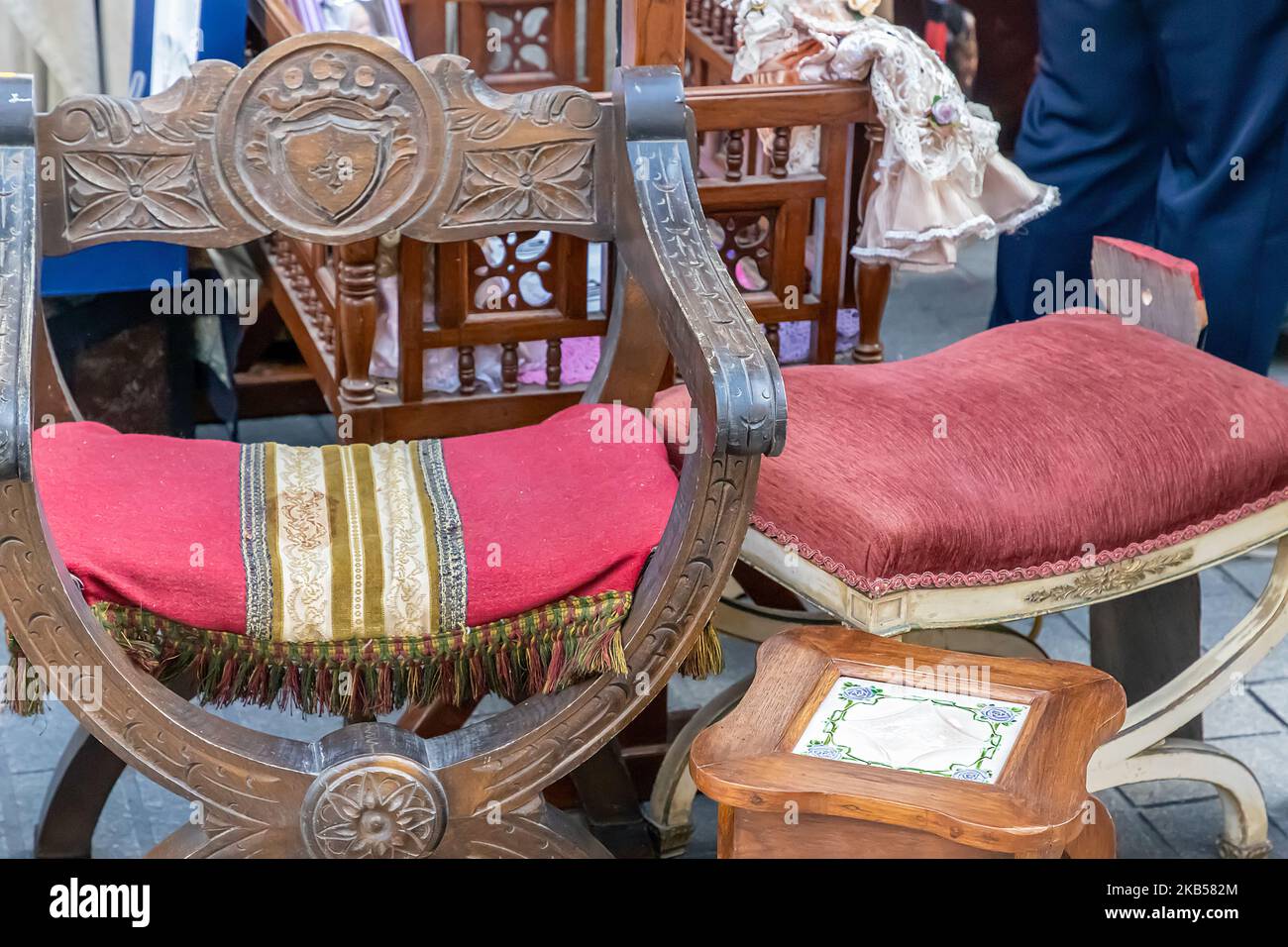 foreground of wooden chairs in an outdoors exhibition for sale of old