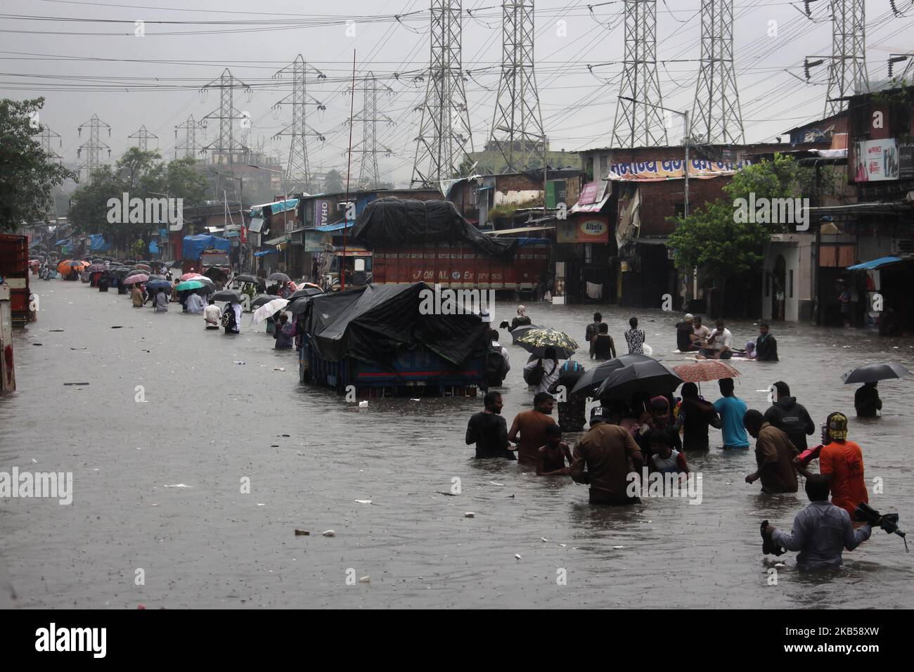 People wade through a flooded street during heavy rains in Mumbai ...