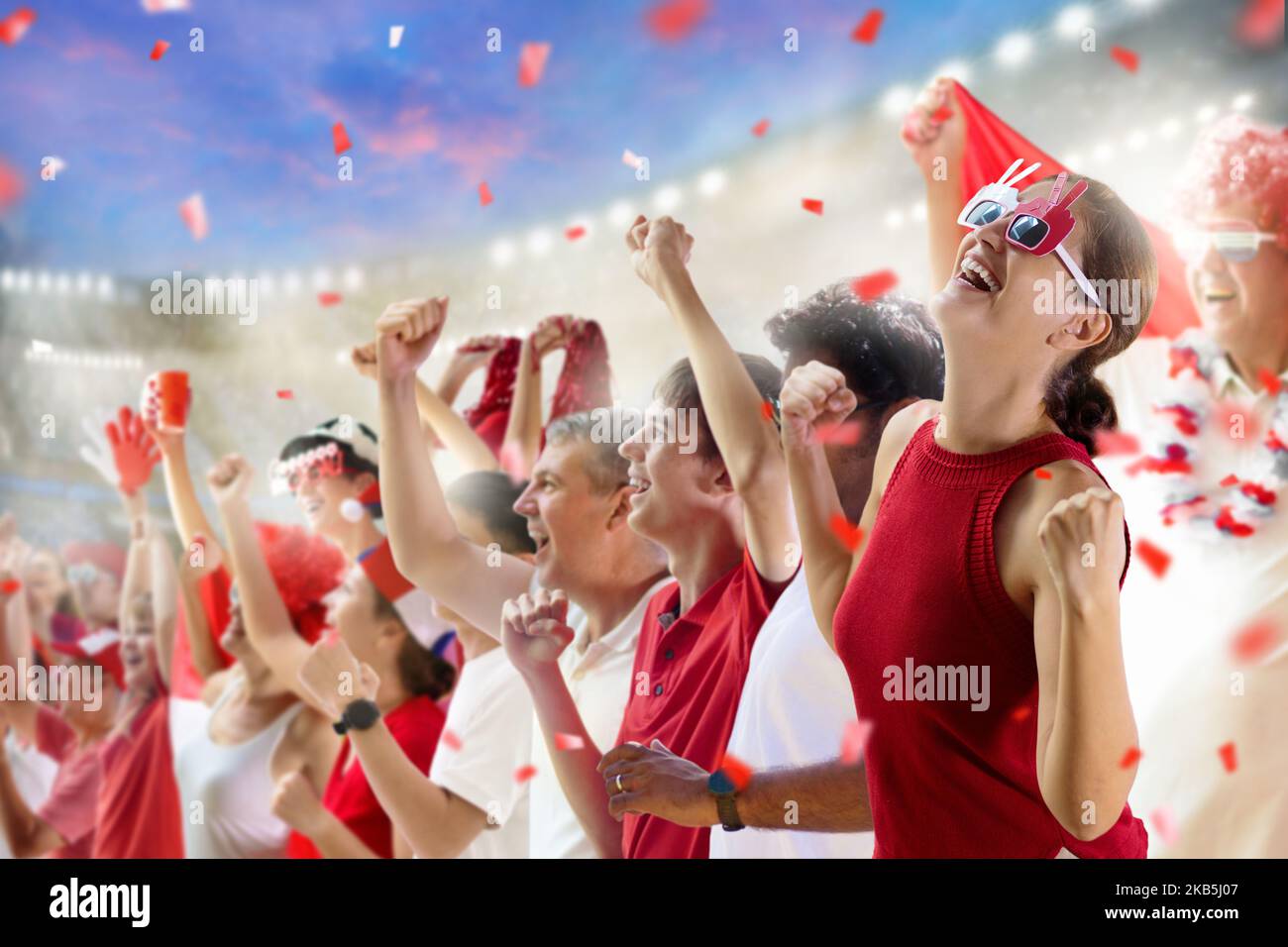 Football supporter on stadium in red and white shirt. Happy fans on
