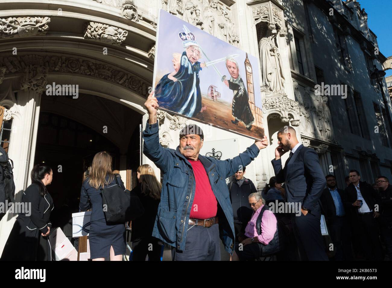 Satirical artist Kaya Mar poses with his artwork depicting (L-R) British Prime Minister Boris Johnson hiding behind Queen Elizabeth II who is engaged in a sword fight with Speaker of the House of Commons John Bercow outside the Supreme Court on 17 September, 2019 in London, England. Today, the Supreme Court judges begin a three-day hearing over the claim that Prime Minister Boris Johnson acted unlawfully in advising the Queen to prorogue parliament for five weeks in order to prevent MPs from debating the Brexit crisis. (Photo by WIktor Szymanowicz/NurPhoto) Stock Photo