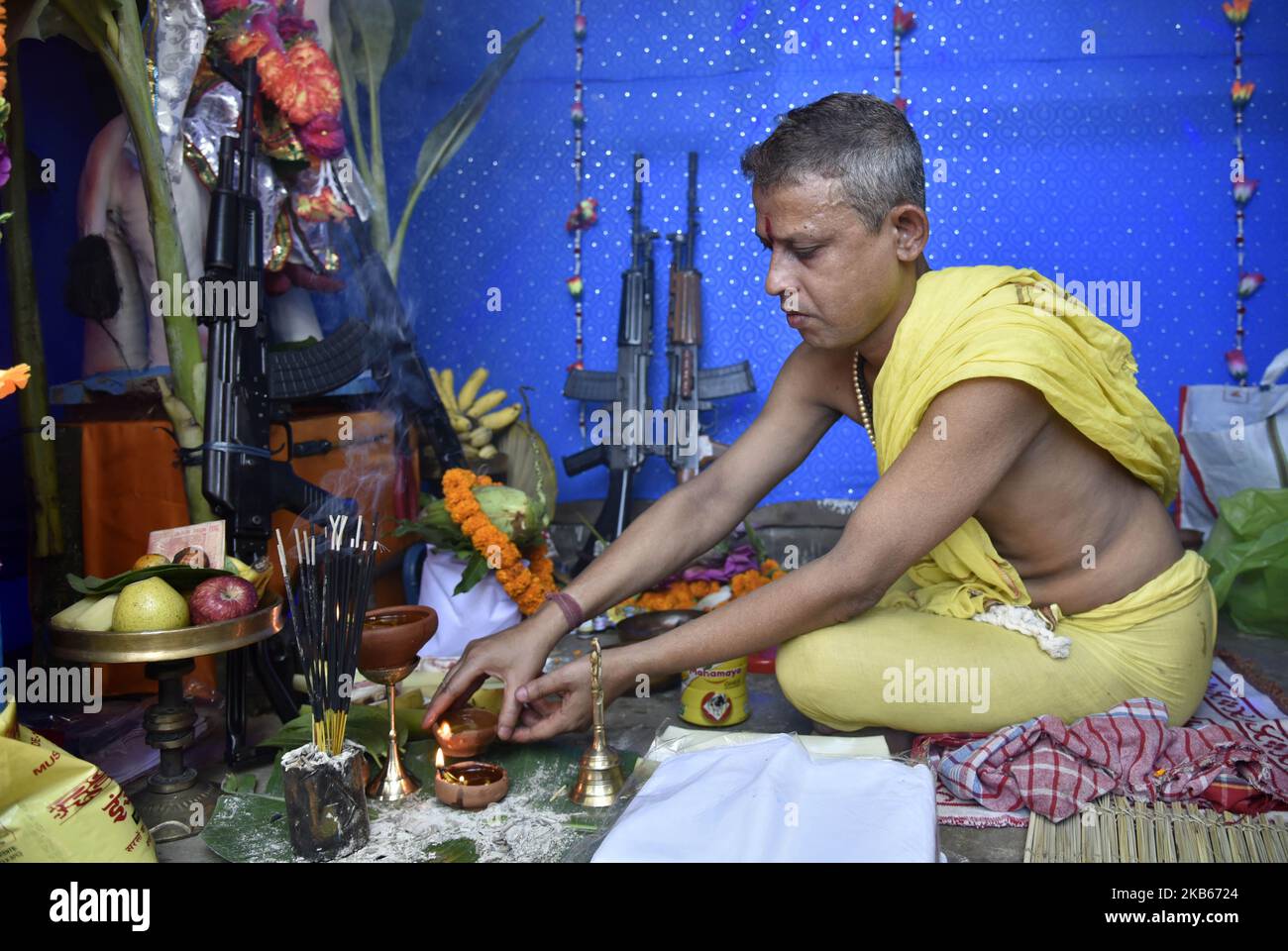 Hindu priest performing rituals as he offers prayers to a clay idol of ...