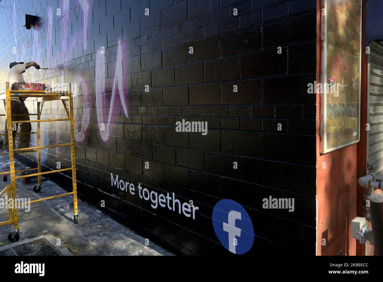 Painters work on an advertisement for the Facebook dating service on a sidewall in the Germantown neighborhood of Philadelphia, PA., on September 20, 2019. Guerrilla Advertising style advertisement for the new dating service is found around town. (Photo by Bastiaan Slabbers/NurPhoto) Stock Photo