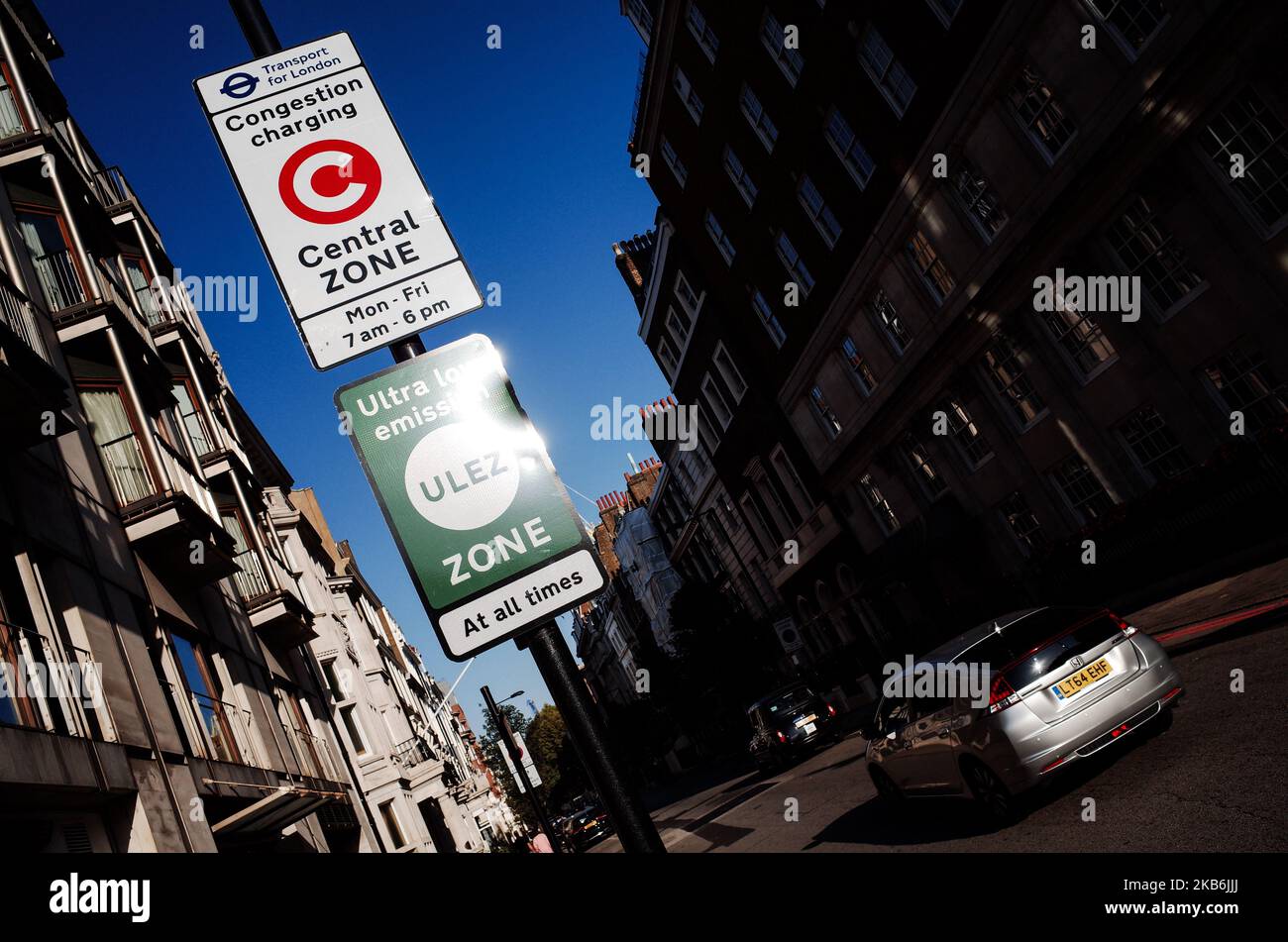 A Honda Prius hybrid car drives past signs for the central London Congestion Charging Zone (CCZ) and Ultra Low Emission Zone (ULEZ) on Upper Brook Street in London, England, on September 21, 2019. (Photo by David Cliff/NurPhoto) Stock Photo