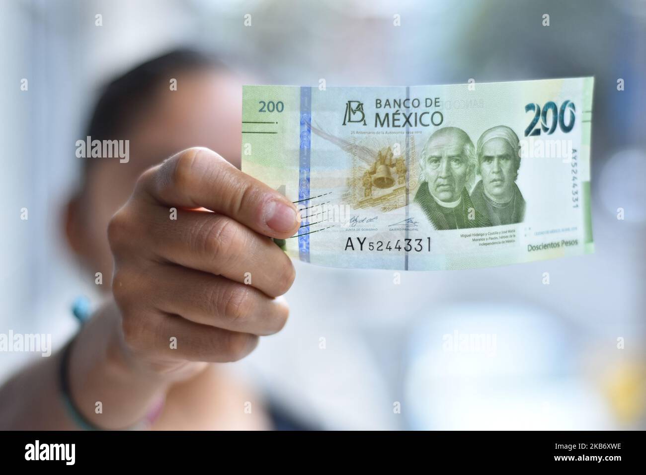 A girl holds the new model of 200 Mexican peso bill that are already in