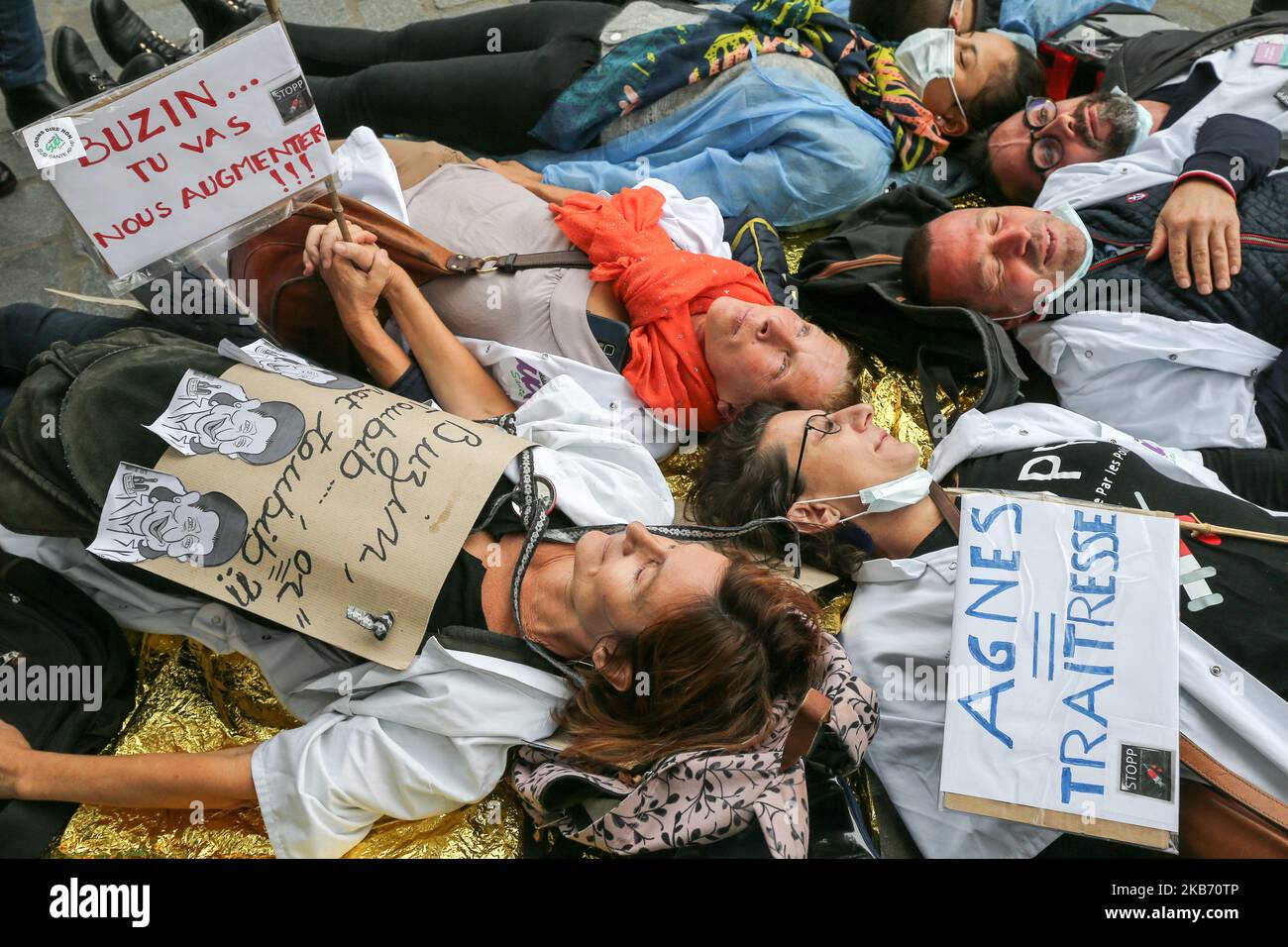 Doctors, nurses and cargivers make a die-in in Paris in front the Hotel de Ville, outside the headquarter of Assistance publique and Hôpitaux de Paris or AP-HP, public hospital system of Paris, to improve the working conditions in the French emergencies services, on September 26, 2019. Emergency hospital staff in France are continuing to strike, with almost half of services affected five months in to the movement. (Photo by Michel Stoupak/NurPhoto) Stock Photo