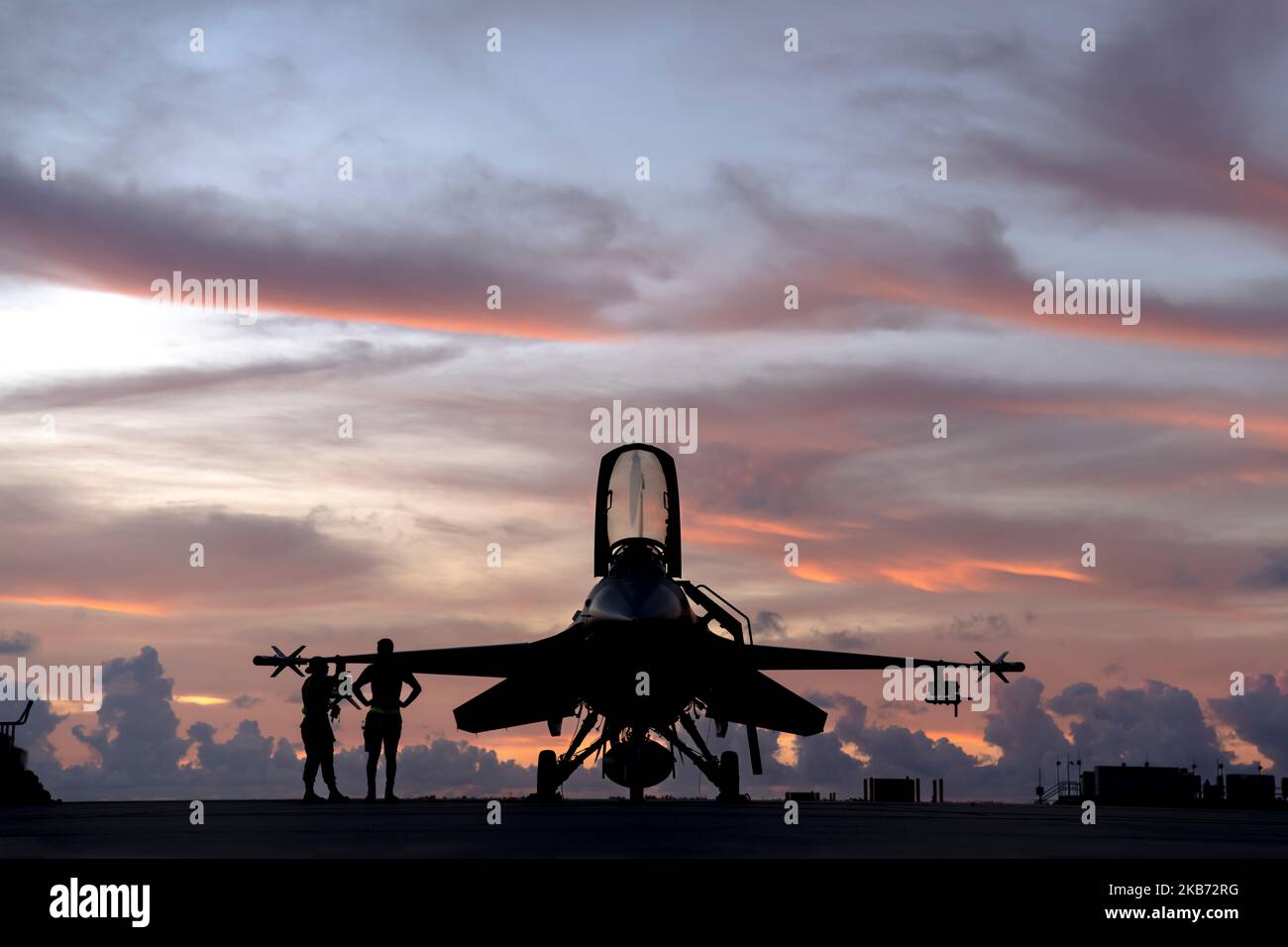U.S. Air Force Staff Sgt. Benjamin Preston, a crew chief assigned to the Ohio National Guard's 180th Fighter Wing, and U.S. Air Force Senior Airman Allison Garcia, a munitions specialist assigned to the 180FW, stand next to an F-16 Fighting Falcon, assigned to the 180FW, before morning training flights at Naval Air Station Key West, Fla., Nov. 3, 2022. The 180FW deployed to Key West to train with VFC-111, the Navy's premier adversary squadron, providing realistic training scenarios that ensure the 180FW is prepared for homeland defense and contingency operations around the globe.  (U.S. Air Na Stock Photo