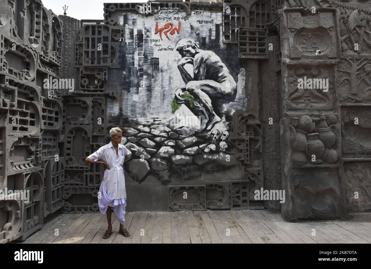 A man stands in front of a painting of a Durga puja pandal in Kolkata, India, 02 October, 2019. The five day Durga Puja festival commemorates the slaying of demon king Mahishasura by Hindu goddess Durga, marking the triumph of good over evil, begins on 04 October, this year. (Photo by Indranil Aditya/NurPhoto) Stock Photo
