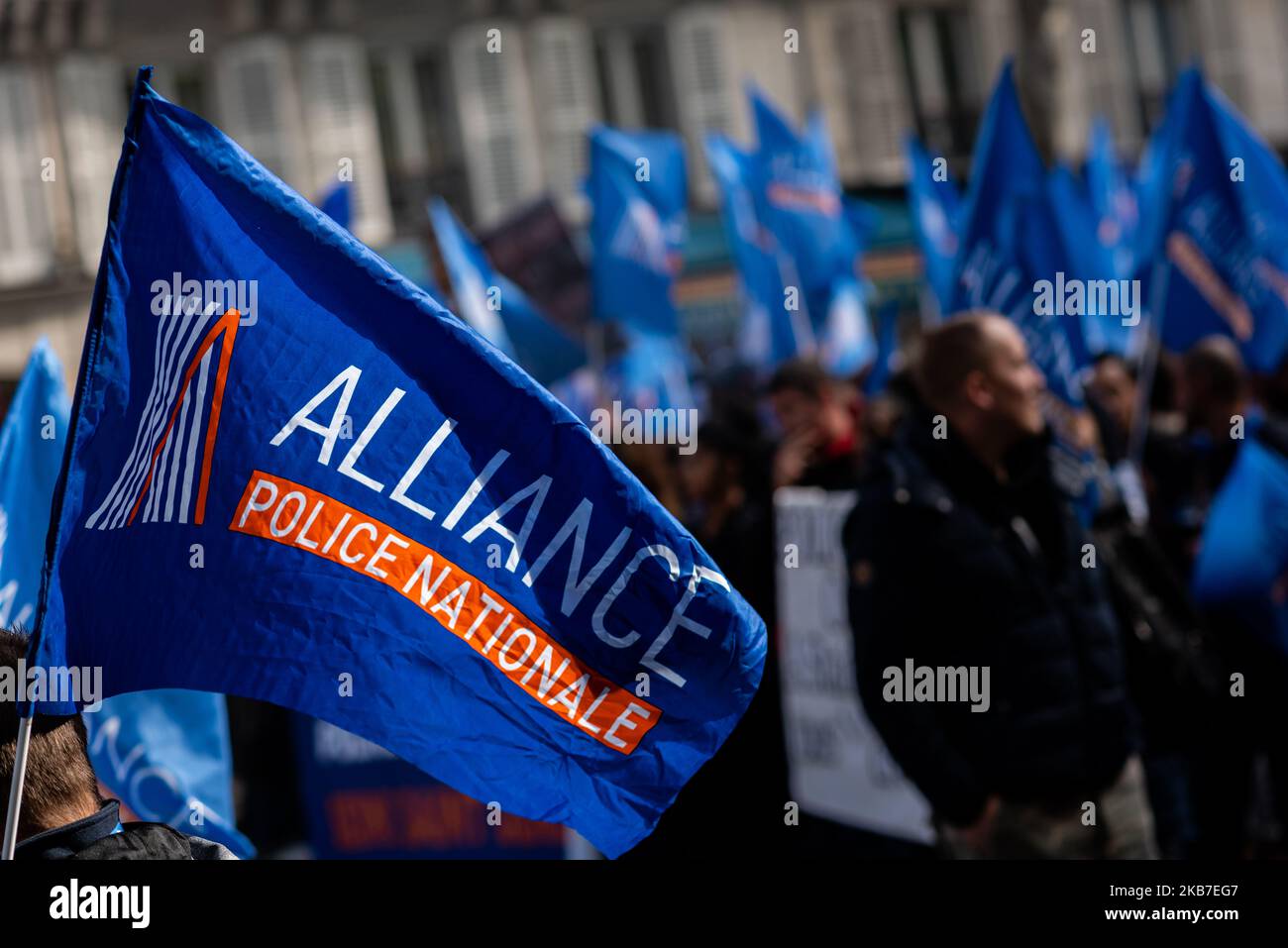 In the foreground, a flag of the Alliance Nationale Nationale union floats in the wind while in the background there is a procession of demonstrators on Wednesday, October 2, 2019, during the police demonstration in Paris at the call of the majority of police unions (including National Police Alliance and SGP Police Unit) for the 'March of anger' between the places of the Bastille and the Place de la République. This historic event day, which brought together more than 20,000 police officers, aimed to raise awareness about working conditions and lack of police resources, but especially about t Stock Photo