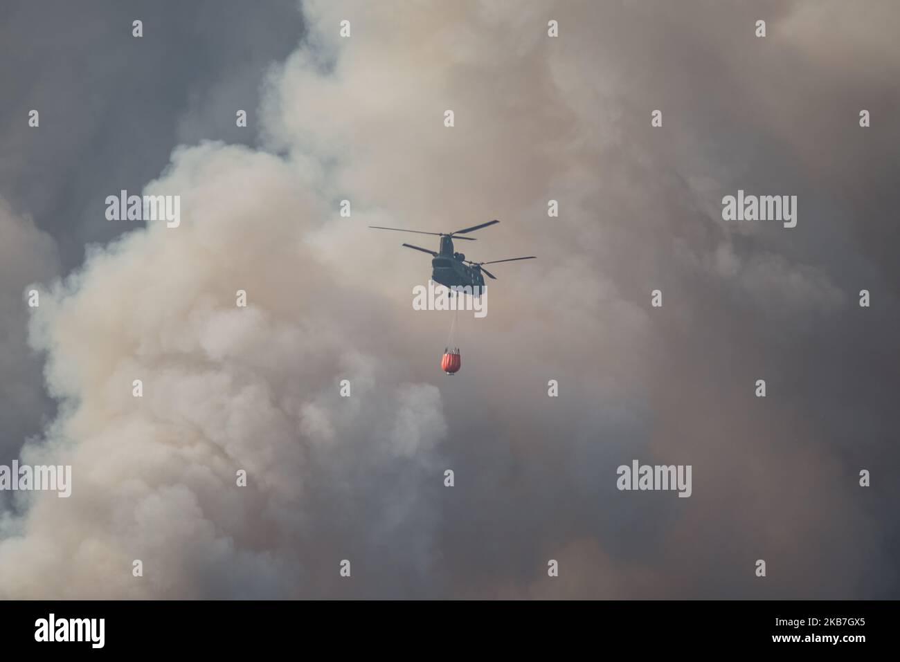 Helicopter pours water near Platania village in Evia, in Euboea, Greece, on August 14, 2019. (Photo by Wassilios Aswestopoulos/NurPhoto) Stock Photo