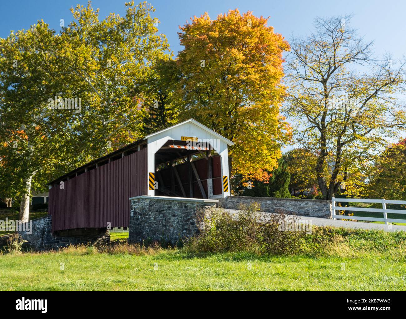 Erb’s Covered Bridge in Autumn. This is a beautiful red covered bridge in Lancaster County, Pennsylvania Stock Photo