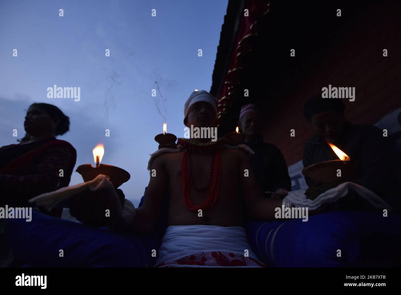 A Nepalese devotee hold oil lamps on his body during the tenth day of