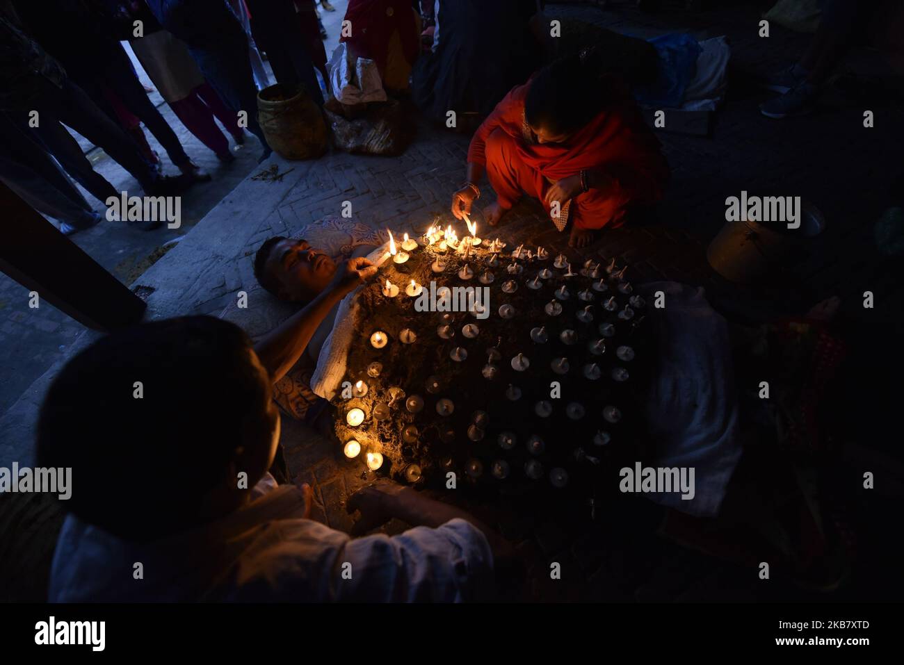 A Nepalese devotee hold oil lamps on his body during the tenth day of
