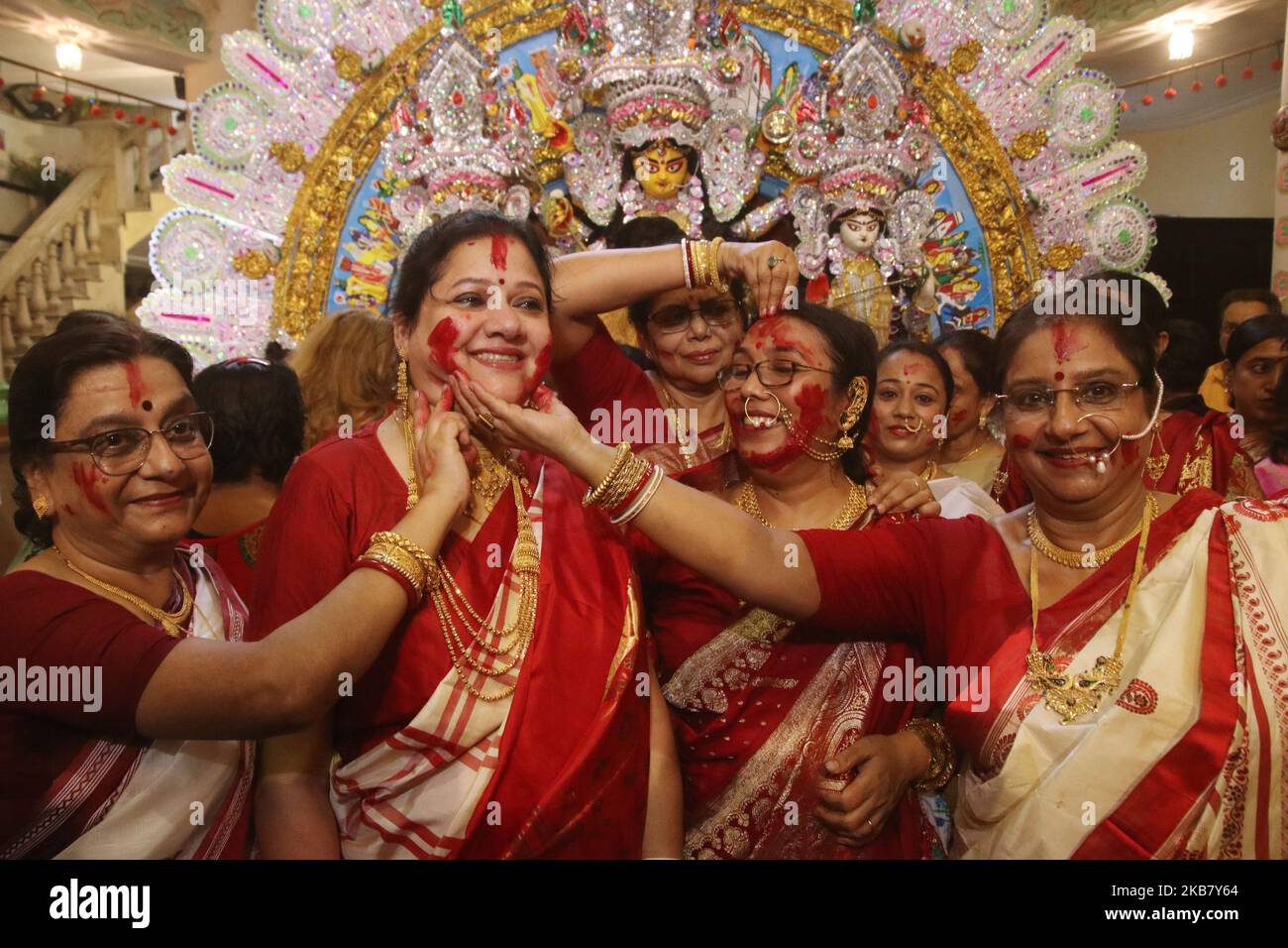 Sindhara Rituals An Indian Hindu devotee smiles as she is smeared with vermillion powder ...