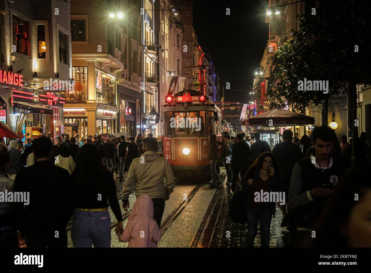 Tourists take souvenir photos with an old-fashioned red tram in Taksim Square and Istiklal Street on a rainy and cold day.The Taksim area of Istanbul is famous for its shopping, restaurants, cafes, bars and dance clubs 08 Oct 2019, Istanbul, Turkey Istanbul(Photo by Momen Faiz/NurPhoto) Stock Photo