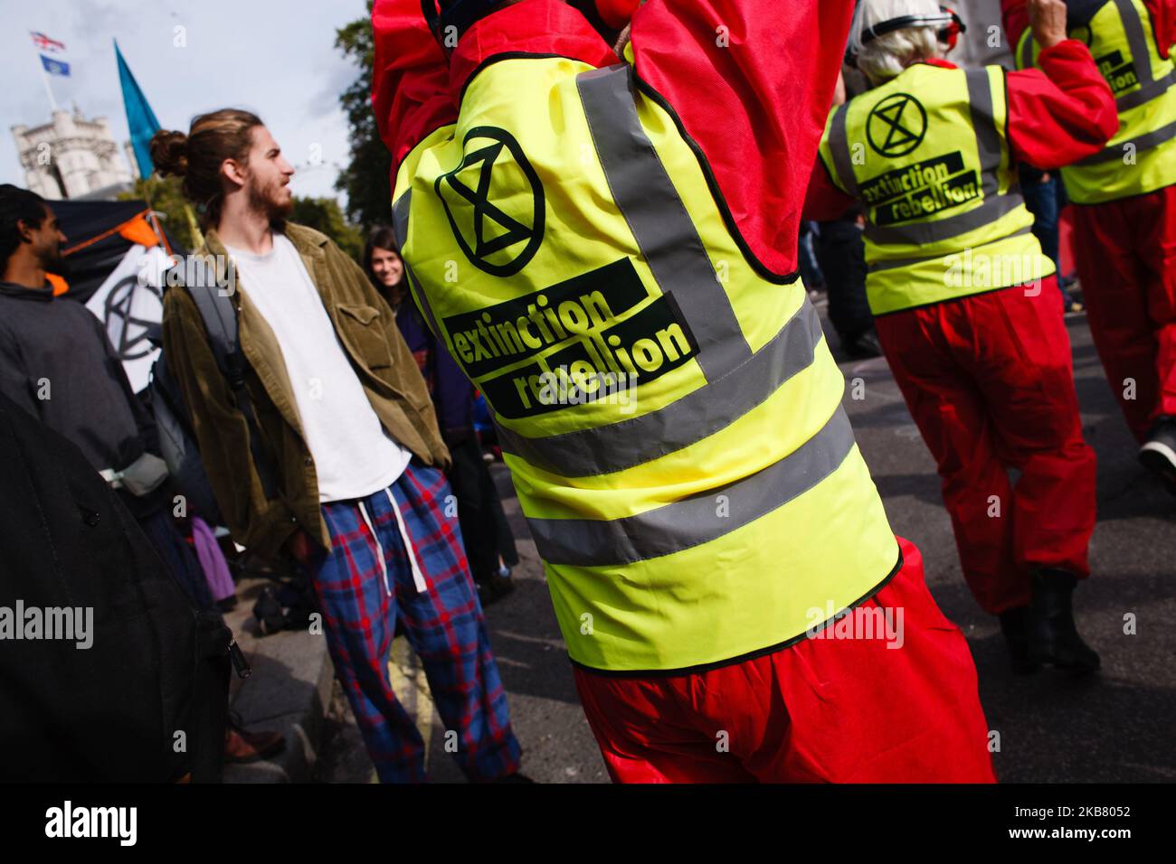 Members of climate change activist movement Extinction Rebellion (XR) dressed as air traffic controllers, with paddles bearing anti-aviation logos, demonstrate on Victoria Street on the third day of the group's 'International Rebellion' in London, England, on October 9, 2019. Police officers today continued to clear demonstrators and tents from sites across Westminster, with activists having been warned yesterday that they must move to a designated protest area around Nelson's Column in Trafalgar Square or face arrest. Similar blockades by Extinction Rebellion in April, at sites including Oxfo Stock Photo
