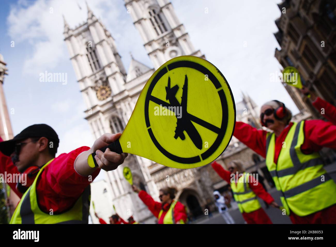 Members of climate change activist movement Extinction Rebellion (XR) dressed as air traffic controllers, with paddles bearing anti-aviation logos, demonstrate in front of Westminster Abbey on the third day of the group's 'International Rebellion' in London, England, on October 9, 2019. Police officers today continued to clear demonstrators and tents from sites across Westminster, with activists having been warned yesterday that they must move to a designated protest area around Nelson's Column in Trafalgar Square or face arrest. Similar blockades by Extinction Rebellion in April, at sites inc Stock Photo
