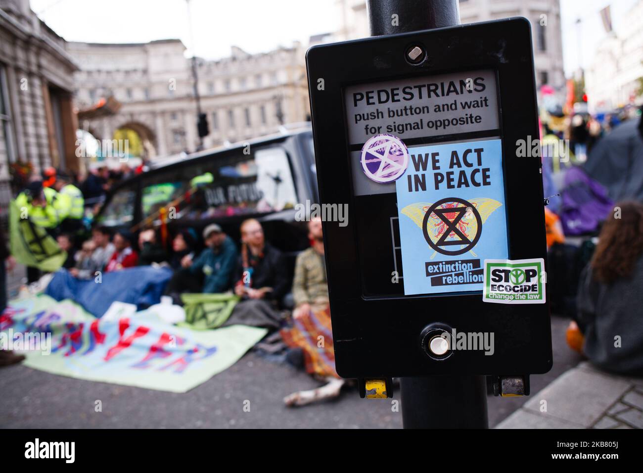 Flyers and stickers of climate change activist movement Extinction Rebellion (XR) cover a pedestrian crossing point in Trafalgar Square on the third day of the group's 'International Rebellion' in London, England, on October 9, 2019. Police officers today continued to clear demonstrators and tents from sites across Westminster, with activists having been warned yesterday that they must move to a designated protest area around Nelson's Column in Trafalgar Square or face arrest. Similar blockades by Extinction Rebellion in April, at sites including Oxford Circus and Waterloo Bridge, saw more tha Stock Photo