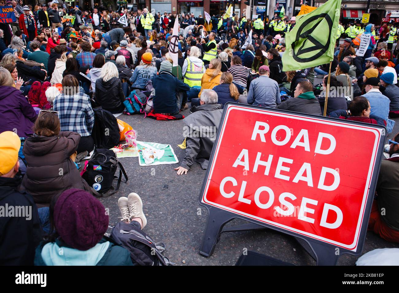Members of climate change activist movement Extinction Rebellion (XR) sit in the road at Trafalgar Square on the fourth day of the group's two-week 'International Rebellion' in London, England, on October 10, 2019. By lunchtime Thursday police had all but contained the demonstrations in Trafalgar Square and the roadways around it, where sizeable numbers of XR followers remained. A hearse carrying a coffin for 'Our Future', which had been parked at the Whitehall exit from the square since Monday, was removed early afternoon. (Photo by David Cliff/NurPhoto) Stock Photo