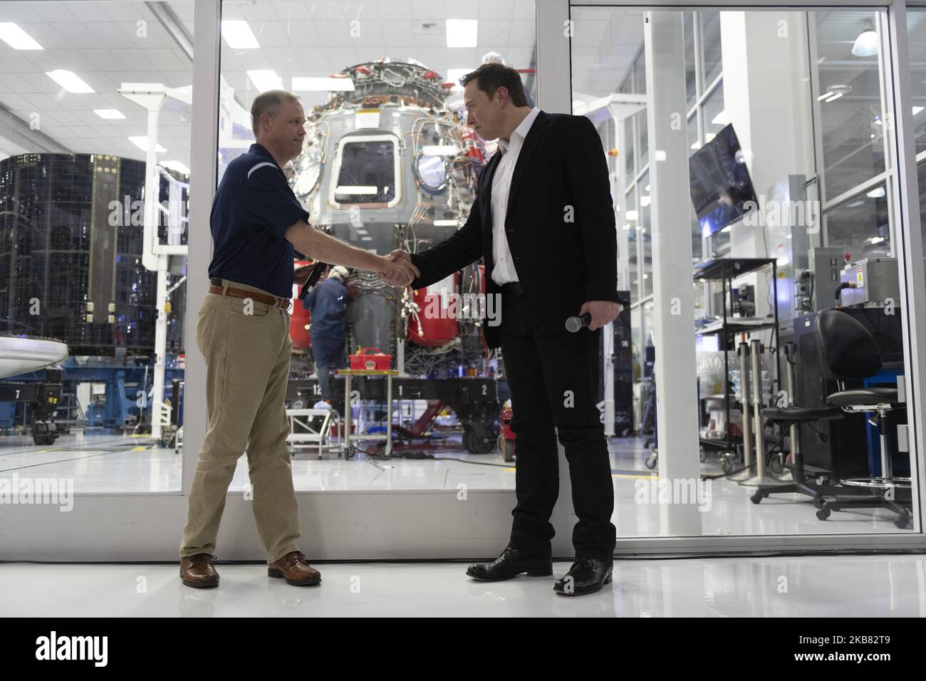NASA administrator Jim Bridenstine and SpaceX Chief Engineer Elon Musk shake hands in front of Crew Dragon cleanroom at SpaceX Headquarters in Hawthorne, California on October 10, 2019. (Photo by Yichuan Cao/NurPhoto) Stock Photo