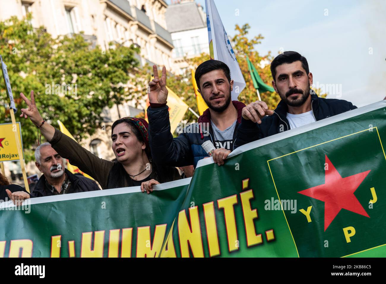Kurdish demonstrators march with signs of support for Kurdish soldiers ...