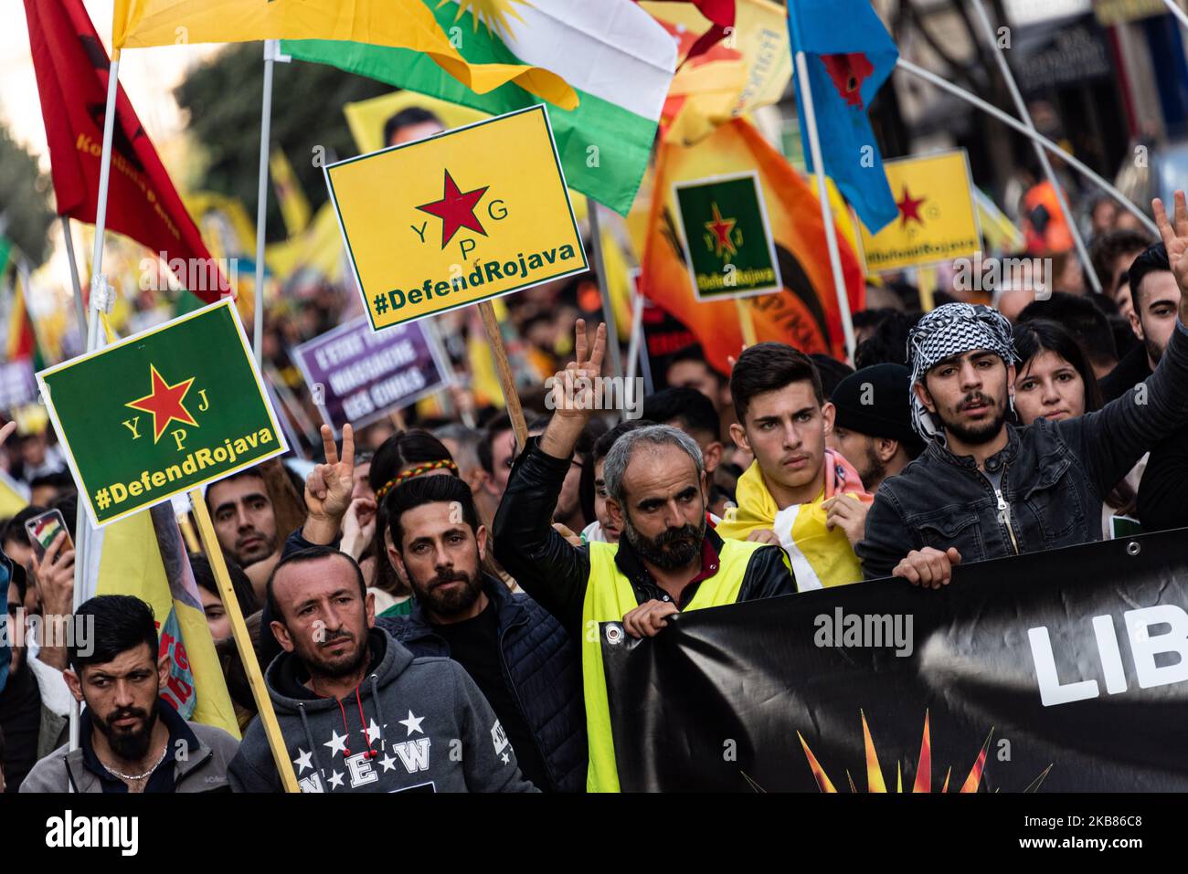 Kurdish demonstrators march with signs of support for Kurdish soldiers ...