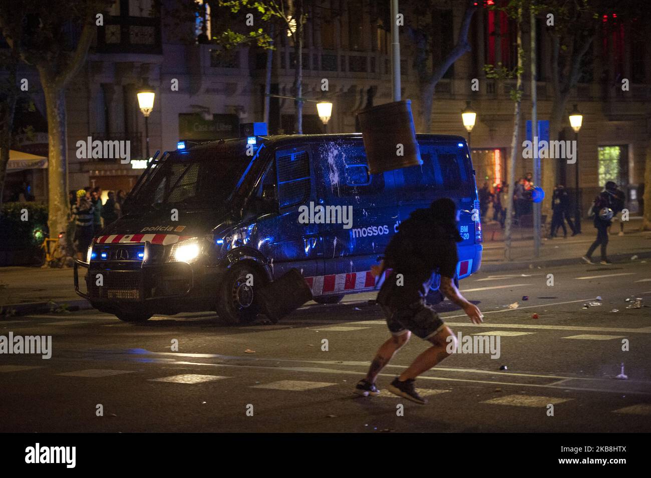 A protester throws a litter bin at the riot police van during the fourth night of riots in Barcelona following the decision of the Superior Court of Justice against the independence leaders who have been imprisoned for nine to thirteen years on October 17, 2019 in Barcelona, Spain. (Photo by Charlie Perez/NurPhoto) Stock Photo