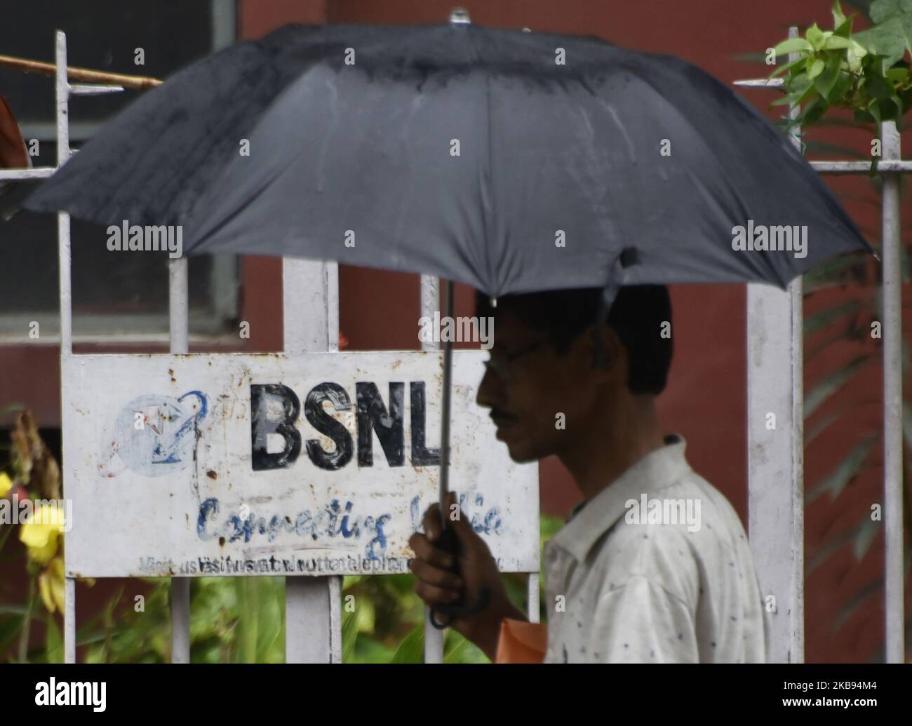 A man walks past a BSNL logo in Kolkata, India, 24 October, 2019. On Wednesday India announced an $8 billion plan to help loss-making state telecom providers Bharat Sanchar Nigam (BSNL) Ltd and Mahanagar Telephone Nigam (MTNL) Ltd catch up with private competitors including merge of both the companies according to an Indian media report. (Photo by Indranil Aditya/NurPhoto) Stock Photo