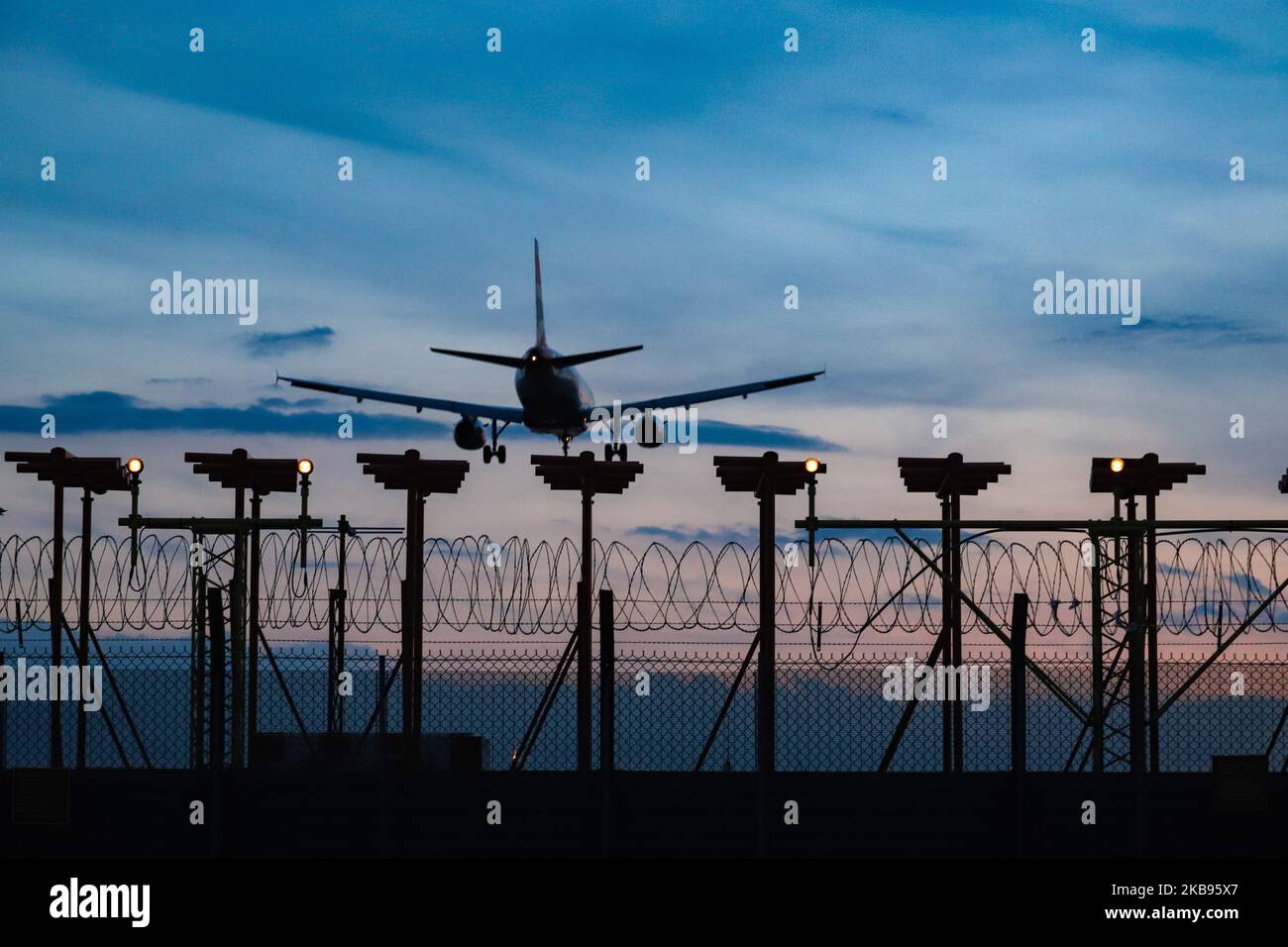 Airplane silhouettes while on final approach landing, during the sunset ...