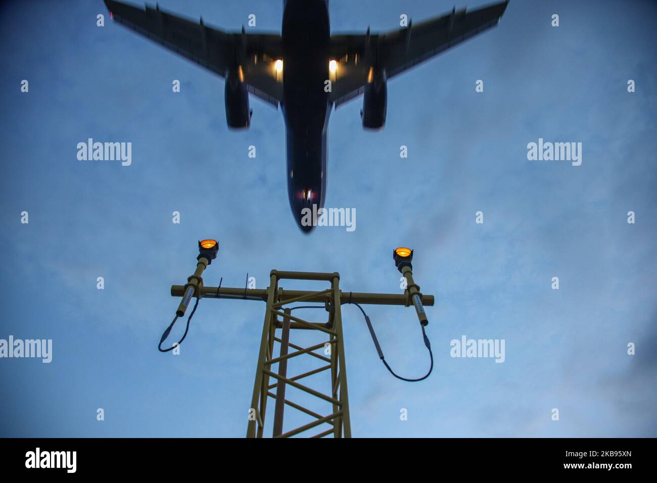Airplane silhouettes while on final approach landing, during the sunset ...